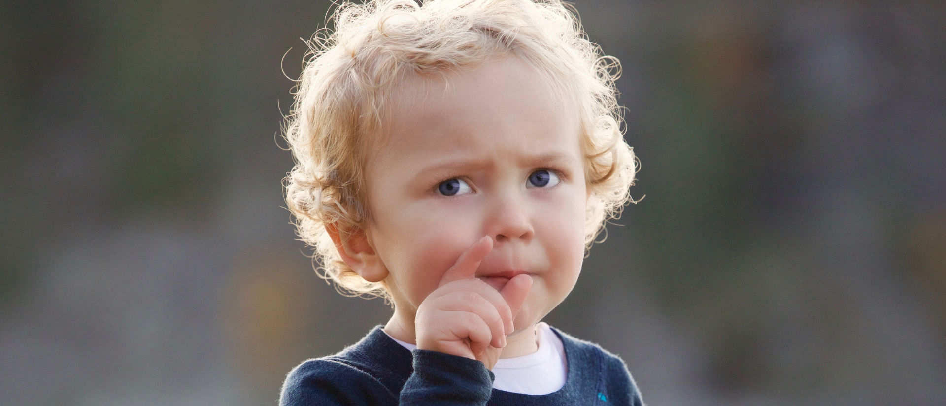 Das Bild zeigt ein Kind beim Grübeln.